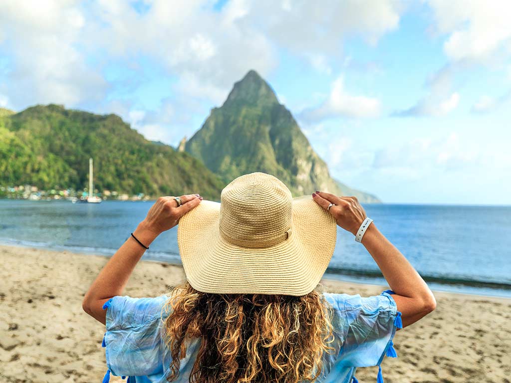 Woman in a sunhat looking at a piton of St. Lucia
