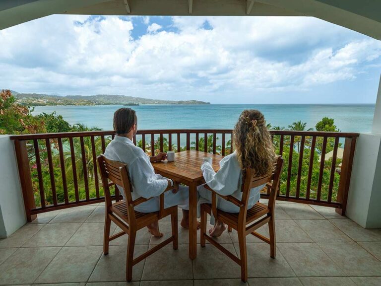 Paar trinkt Kaffee auf seinem privaten Balkon mit Blick auf den Ozean