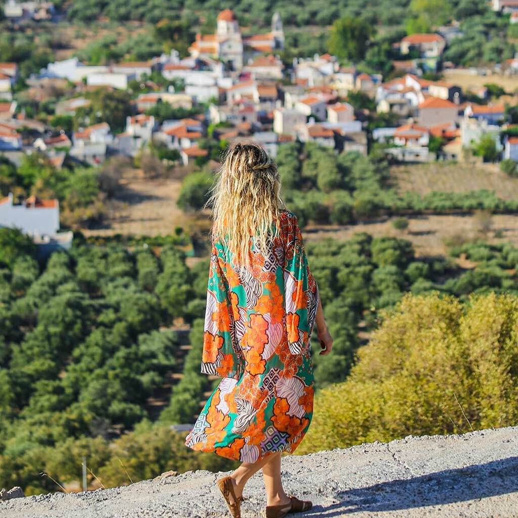 Mujer que mira un pueblo en la distancia en Creta, Grecia