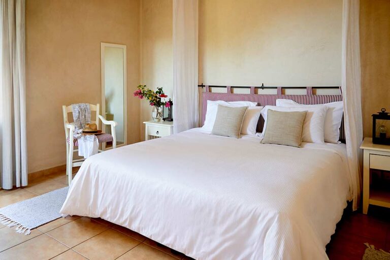 Suite mit einem Schlafzimmer mit Kingsize-Bett und Beistellstuhl im Village Heights Resort