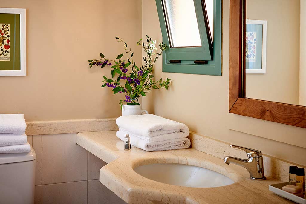 One Bedroom Suite bathroom sink, toiletries, and towels at the Village Heights Resort