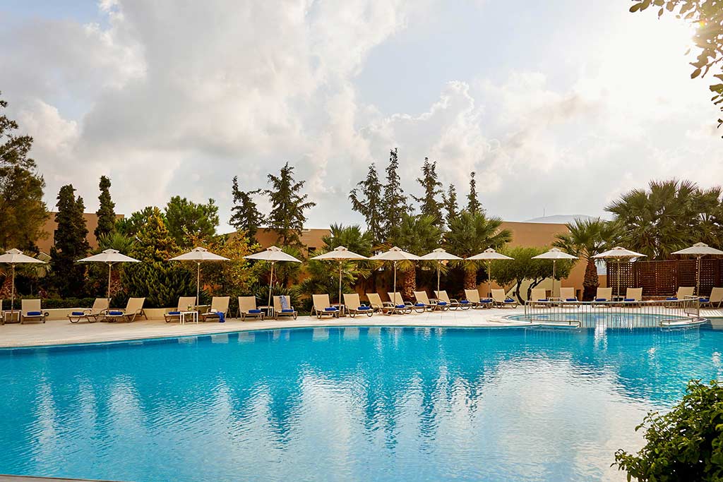 Outdoor pool surrounded by lounge chairs at the Village Heights Resort