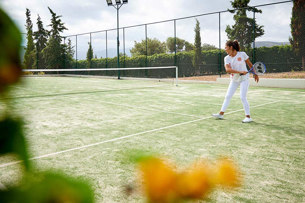 Frau spielt Tennis auf einem Rasenplatz