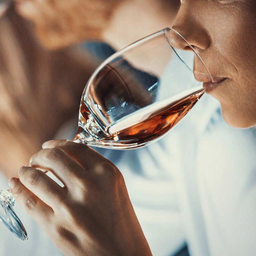 Frau, die ein Glas Wein probiert