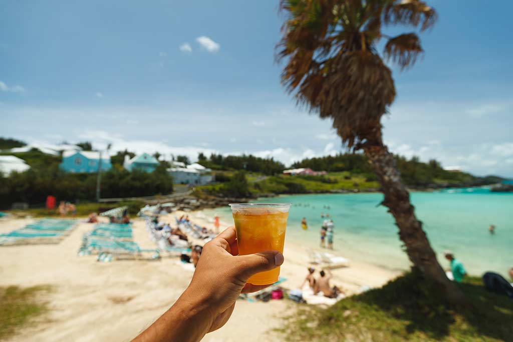 Person holding a cocktail at a beach