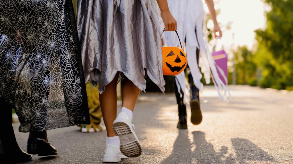 Group of kids in costumes trick-or-treating for Halloween
