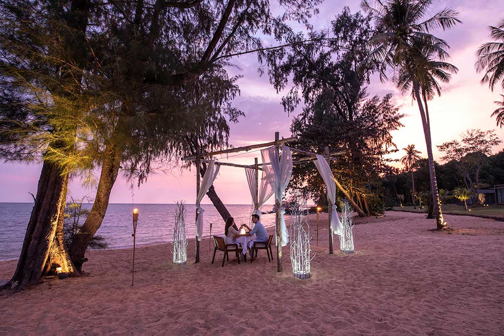 Pareja de Koh Russey Villas & Resort disfrutando de una experiencia gastronómica privada frente al mar