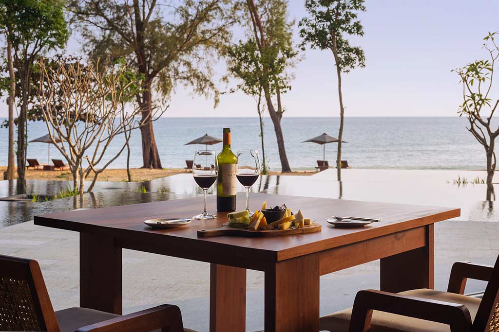 Asientos al aire libre en el restaurante Horizon con vista al agua en Koh Russey Villas & Resort