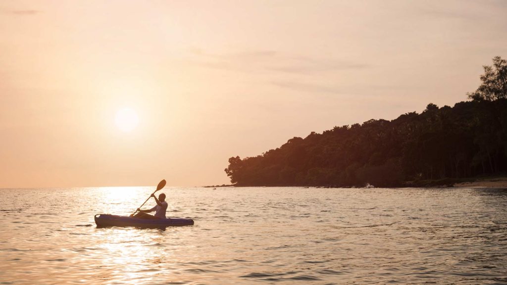 Hombre haciendo kayak en el océano en Koh Russey Villas & Resort