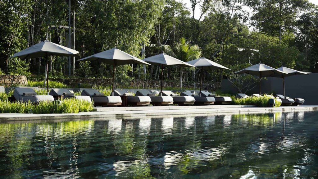 Fila de tumbonas junto a la piscina en Koh Russey Villas & Resort