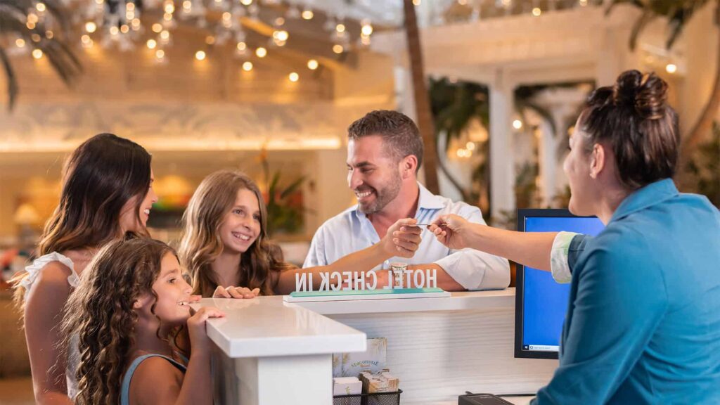Concierge agent greets a family at the Margaritaville Resort Orlando lobby.