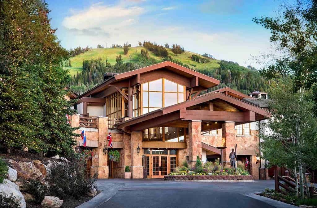 Stein Eriksen Lodge entrance in summer with grass-covered ski slopes in the background