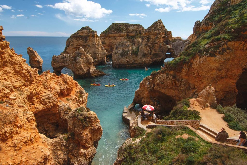 Menschen Kajak entlang der Klippen am Meer der Algarve, Portugal