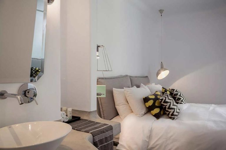 Boheme Mykonos - Deluxe Suite bed and bathroom vanity