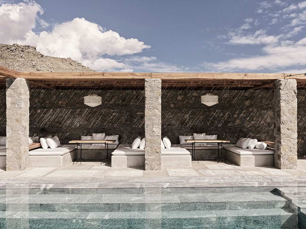 Outdoor cabanas by a pool at Nomad Mykonos