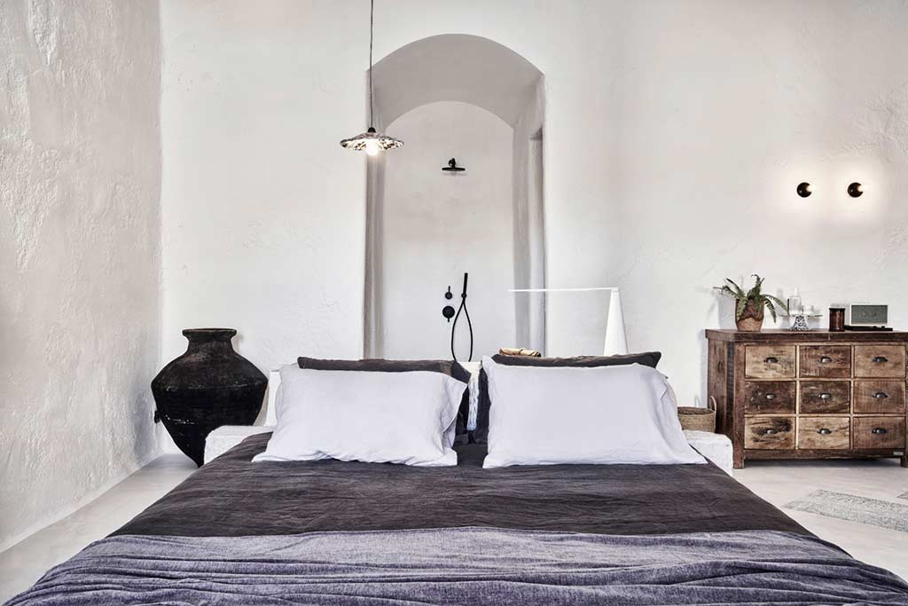 Nomad Mykonos - Interior de Cave Suite con cama y ducha de lluvia