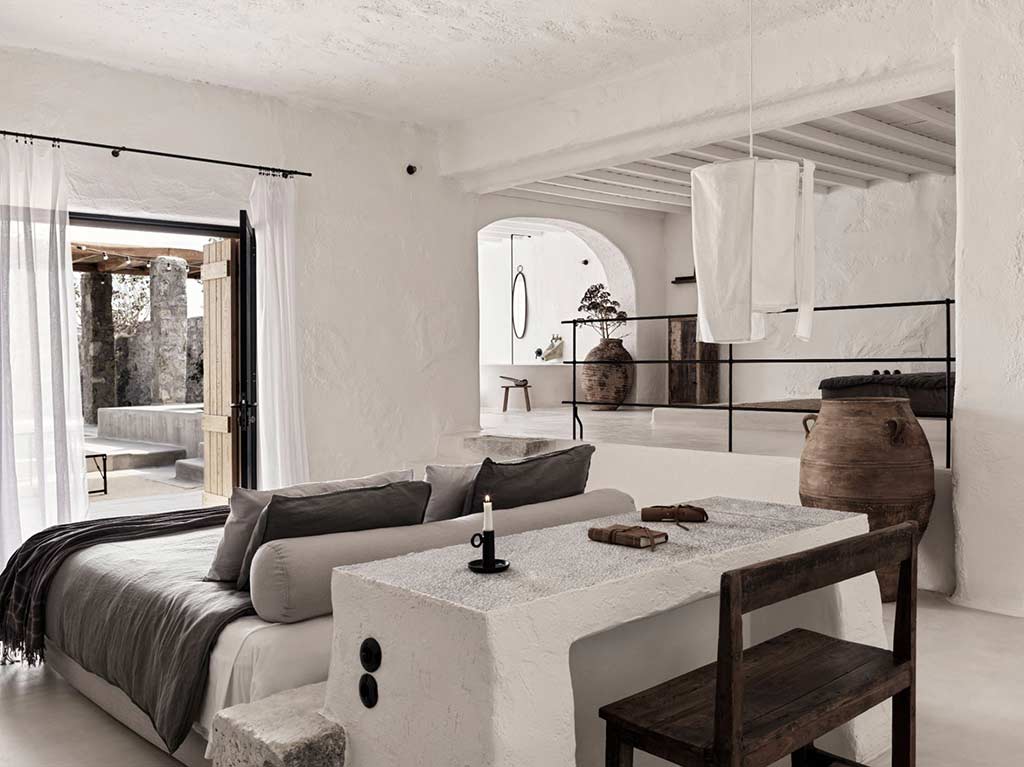 Nomad Mykonos – Bett und Arbeitsplatz der Nomad Suite mit Blick auf die Außenterrasse