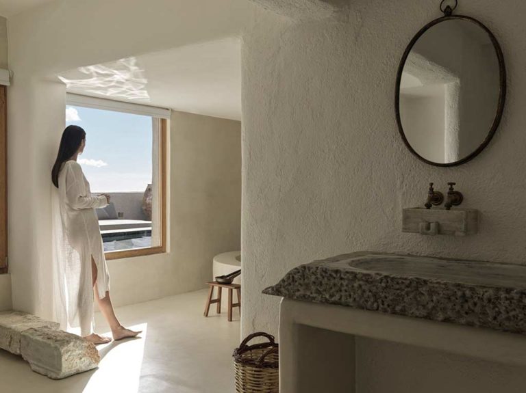 Nomad Mykonos - Woman standing in the bathroom of the Nomad Suite Sea View