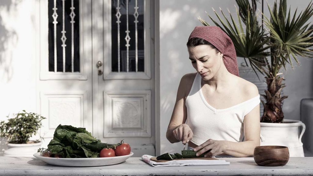 Woman chopping vegetables at Nomad Mykonos