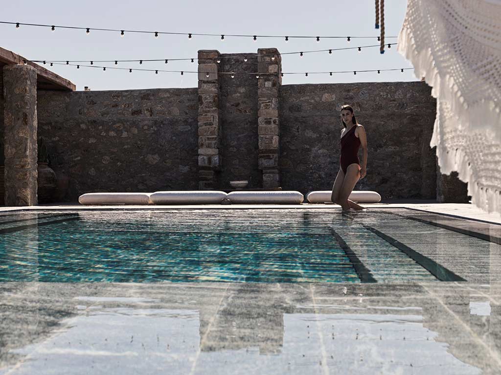 Woman walking into a pool at Nomad Mykonos