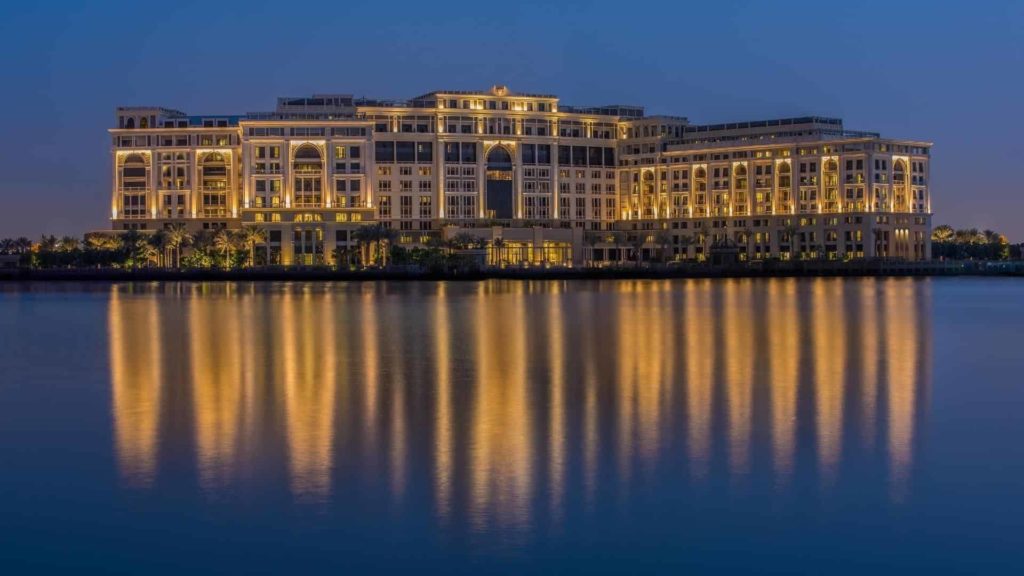 Exterior view of the Palazzo Versace Dubai Hotel by a river at night