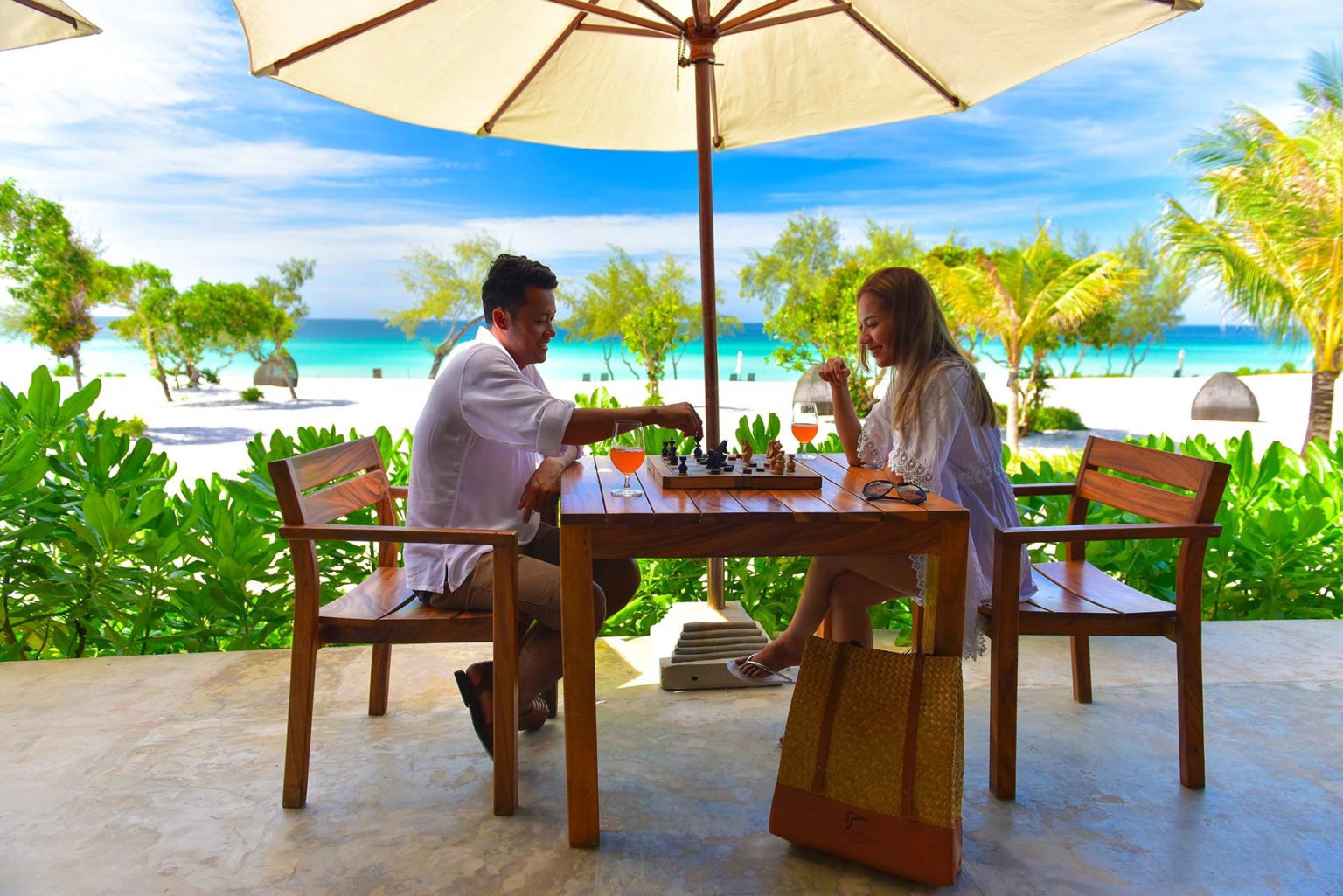 Couple playing a game of chess on a patio at the Royal Sands Koh Rong