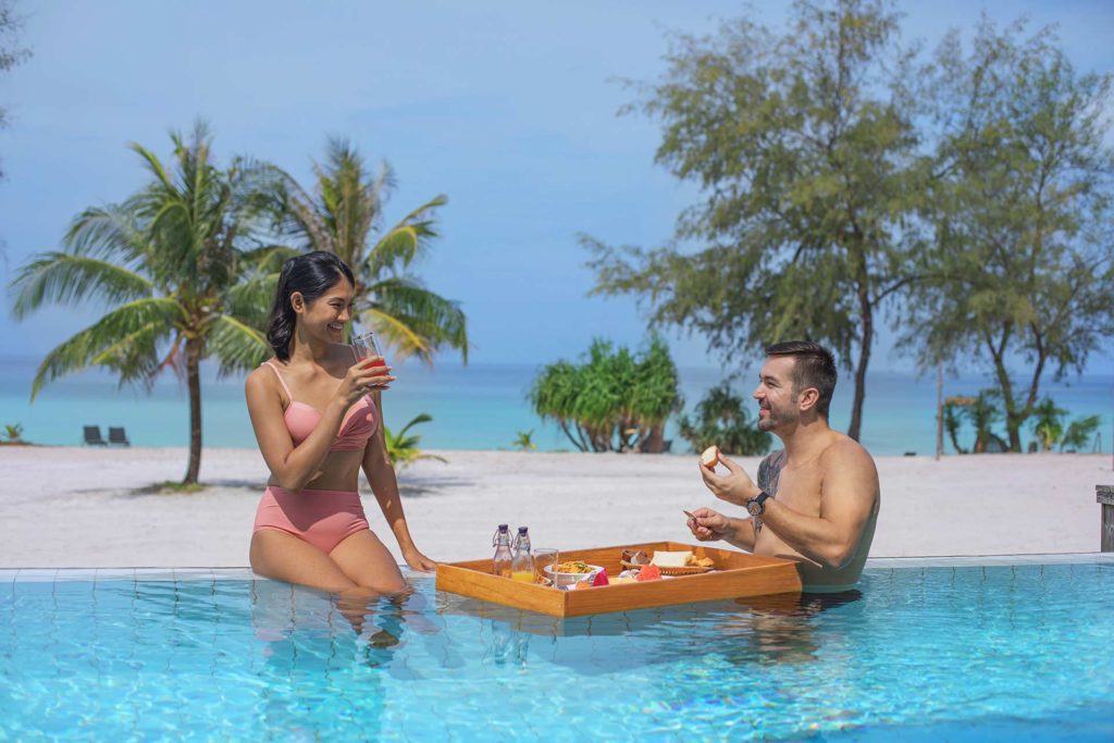 زوجان يستمتعان بالوجبات الخفيفة في المسبح اللامتناهي في Royal Sands Koh Rong