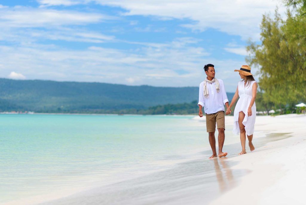 Couple holding hands while walking on the beach at the Royal Sands Koh Rong