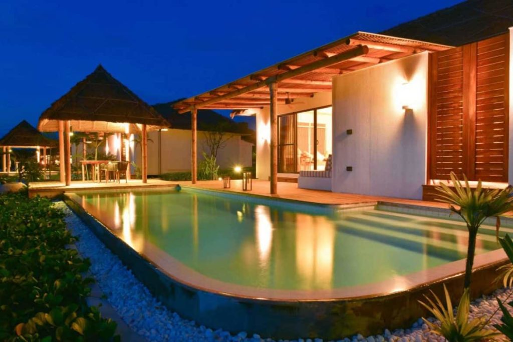 Vista nocturna de la terraza y la piscina de la villa privada Ocean View Pool Villa en Royal Sands Koh Rong