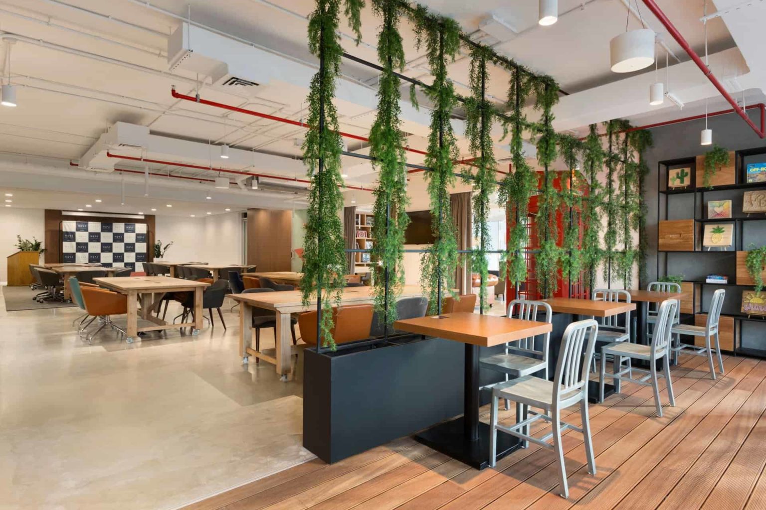 TRYP by Wyndham Dubai business center with tables, desks, and a trellis with decorative plants
