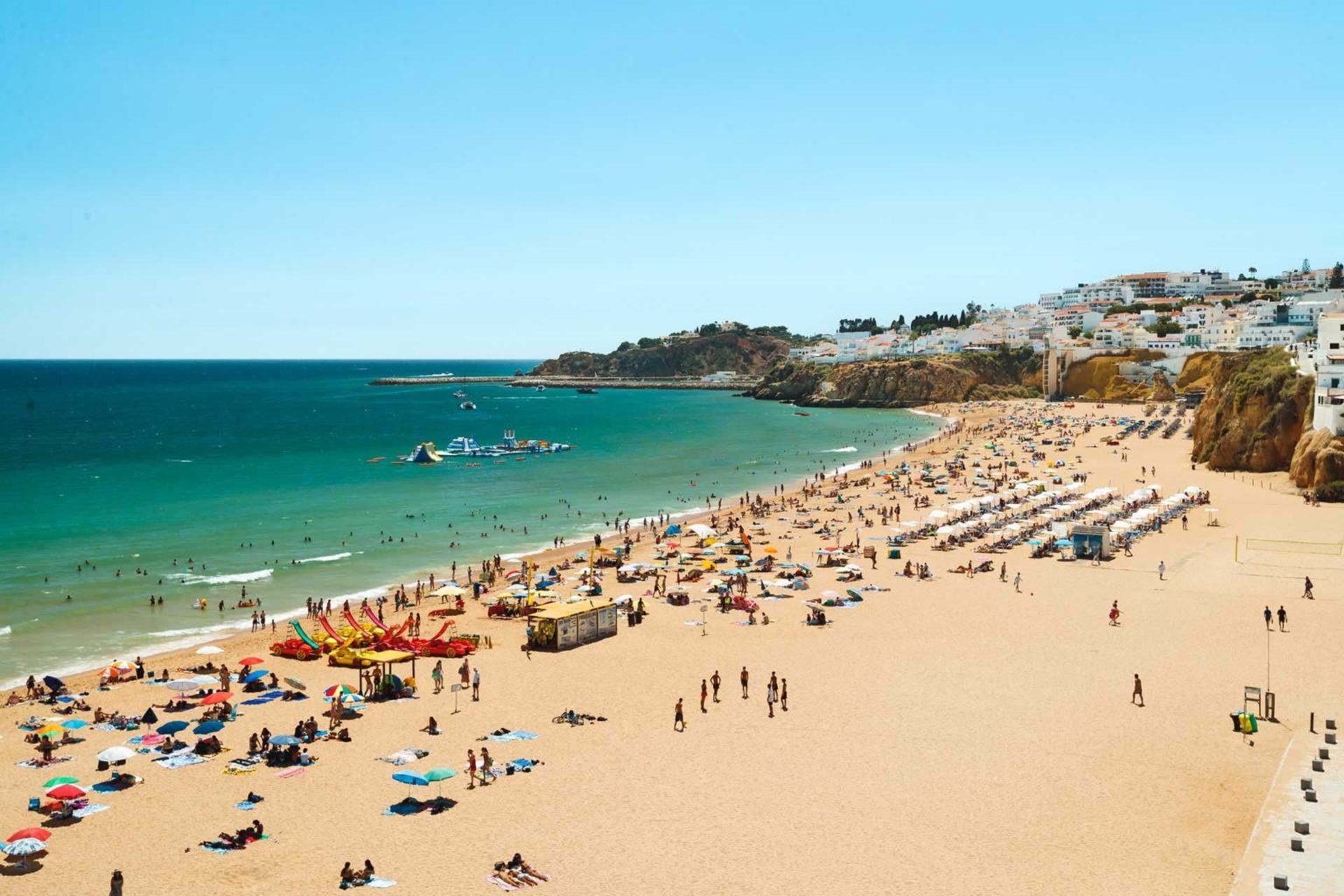Viewpoint of the Miradouro do Pau da Bandeira looking out at a crowded beach in Albufeira, Portugal