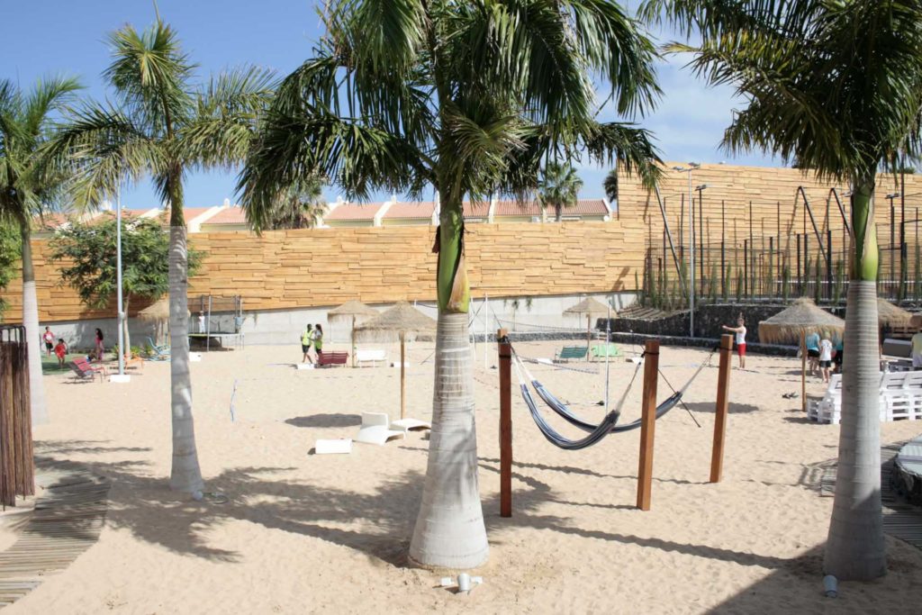 Outdoor sand volleyball courts, hammocks, and palm trees at the Activate Sports Club | Bacbab Suites
