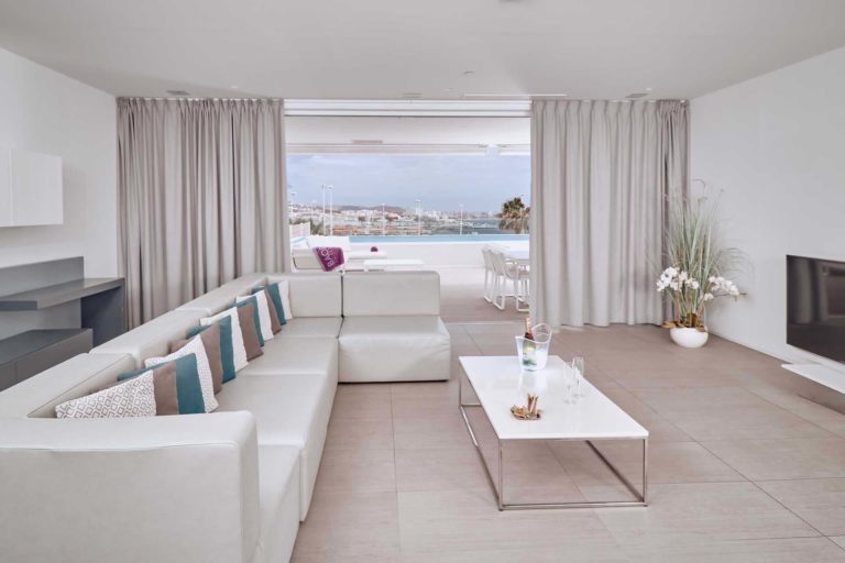 Sala de estar de la suite Divinity Breeze con vistas a la terraza al aire libre y la piscina | Suites Baobab