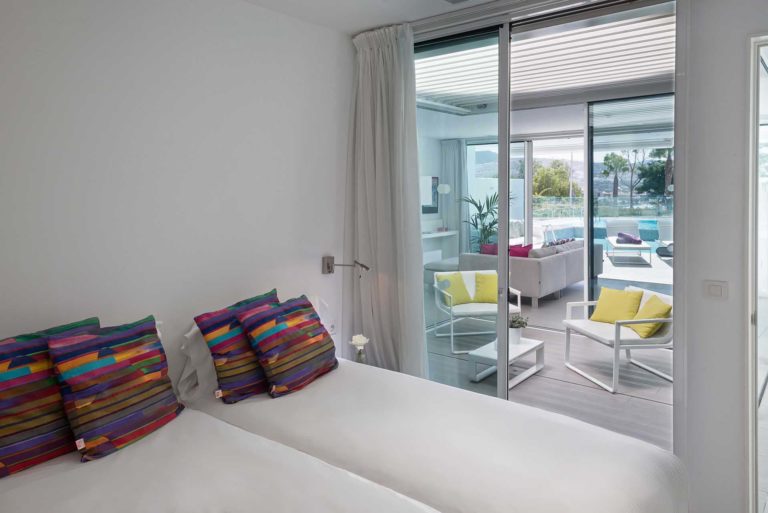 Dormitorio en suite Divinity Rio con puerta corrediza que conduce a la sala de estar | Suites Baobab