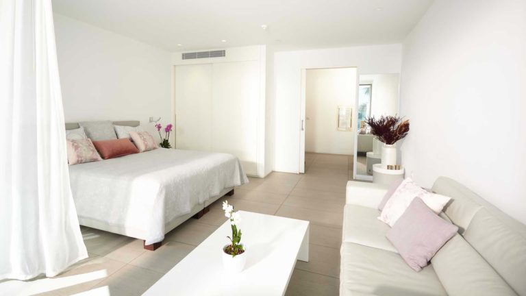 Dormitorio y sala de estar de la suite Divinity Studio | Suites Baobab