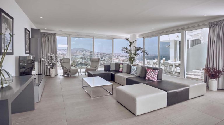 Amplia sala de estar de la suite Infinity Indulgence con vista a la montaña y al mar | Suites Baobab