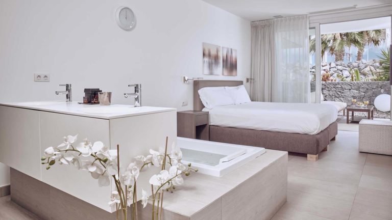 Dormitorio en suite Infinity Mar y baño en suite con puertas correderas que dan a la terraza | Suites Baobab
