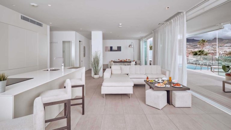 Cocina de concepto abierto, sala de estar y comedor de la suite Infinity Mar con puertas corredizas que conducen a la terraza | Suites Baobab