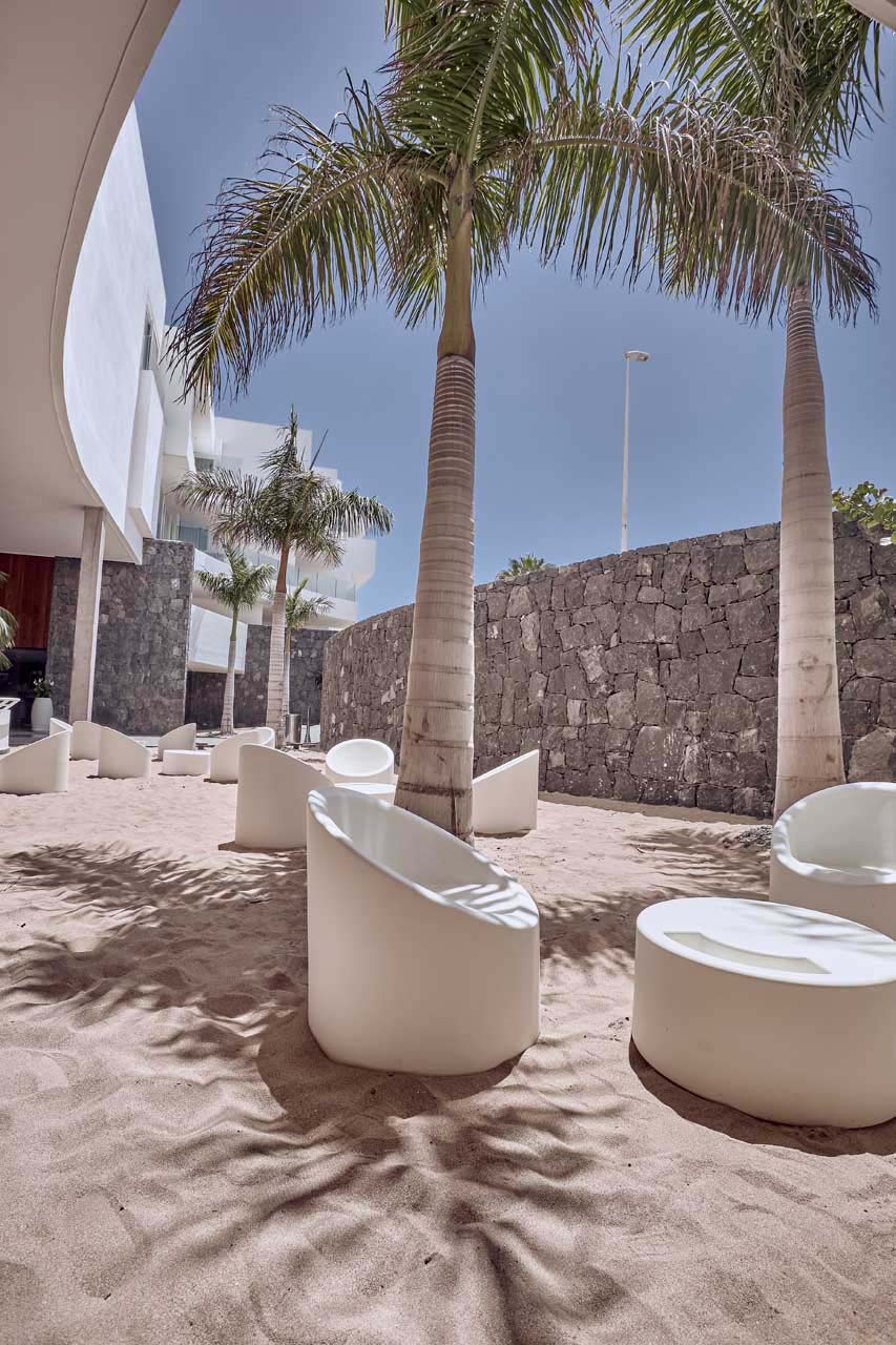 Baobab Suites open air lobby seating areas on sand surrounded by palm trees