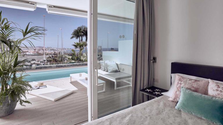 Dormitorio en suite Serenity Mar con puertas corredizas que dan a la terraza | Suites Baobab