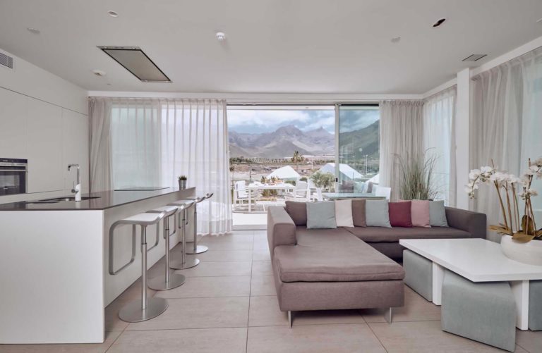 Sala de estar y cocina de concepto abierto de la suite Serenity Pico con vista a la montaña | Suites Baobab