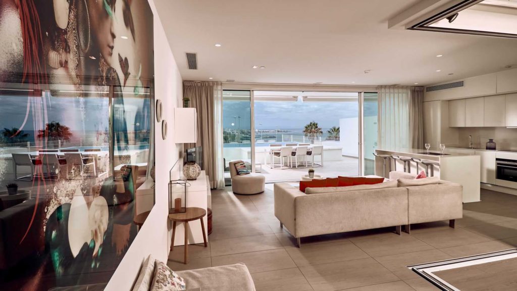 Sala de estar y cocina de concepto abierto de la suite Serenity Rio con vista al mar | Suites Baobab