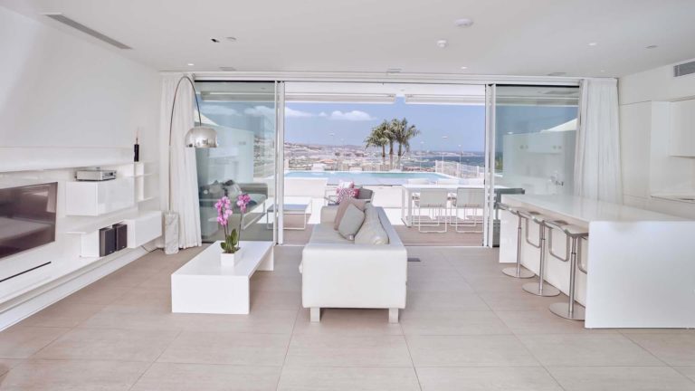 Sala de estar y cocina de concepto abierto de la suite Serenity Rio con vista al mar | Suites Baobab