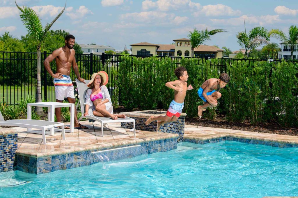 Young boys jumping into a pool at their private resort home at the Bear's Den Resort Orlando