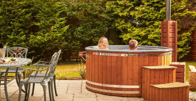 Outdoor dining table and hot tub of the lodge at Brockencote Hall