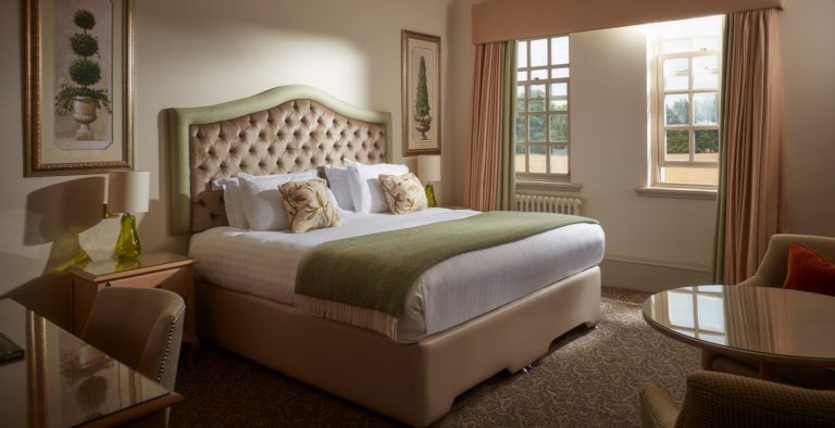 Dormitorio principal con cama King, sala de estar y estación de trabajo en Brockencote Hall