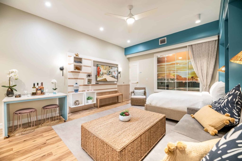 Dormitorio en suite con cama Queen, sofá, mesa de centro y TV en Embassy Suites by Hilton Orlando Sunset Walk