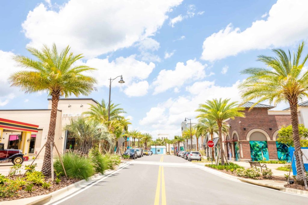 The Promenade at Sunset Walk street lined with palm trees and shops