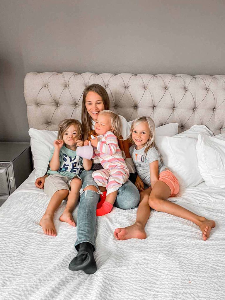 Mamá e hijos relajándose en la cama de su casa de vacaciones privada en Encore Resort en reunión