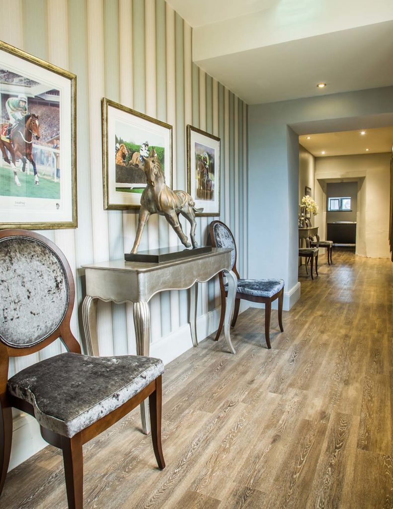 Pasillo con sala de estar y obras de arte de caballos en el Greenway Hotel
